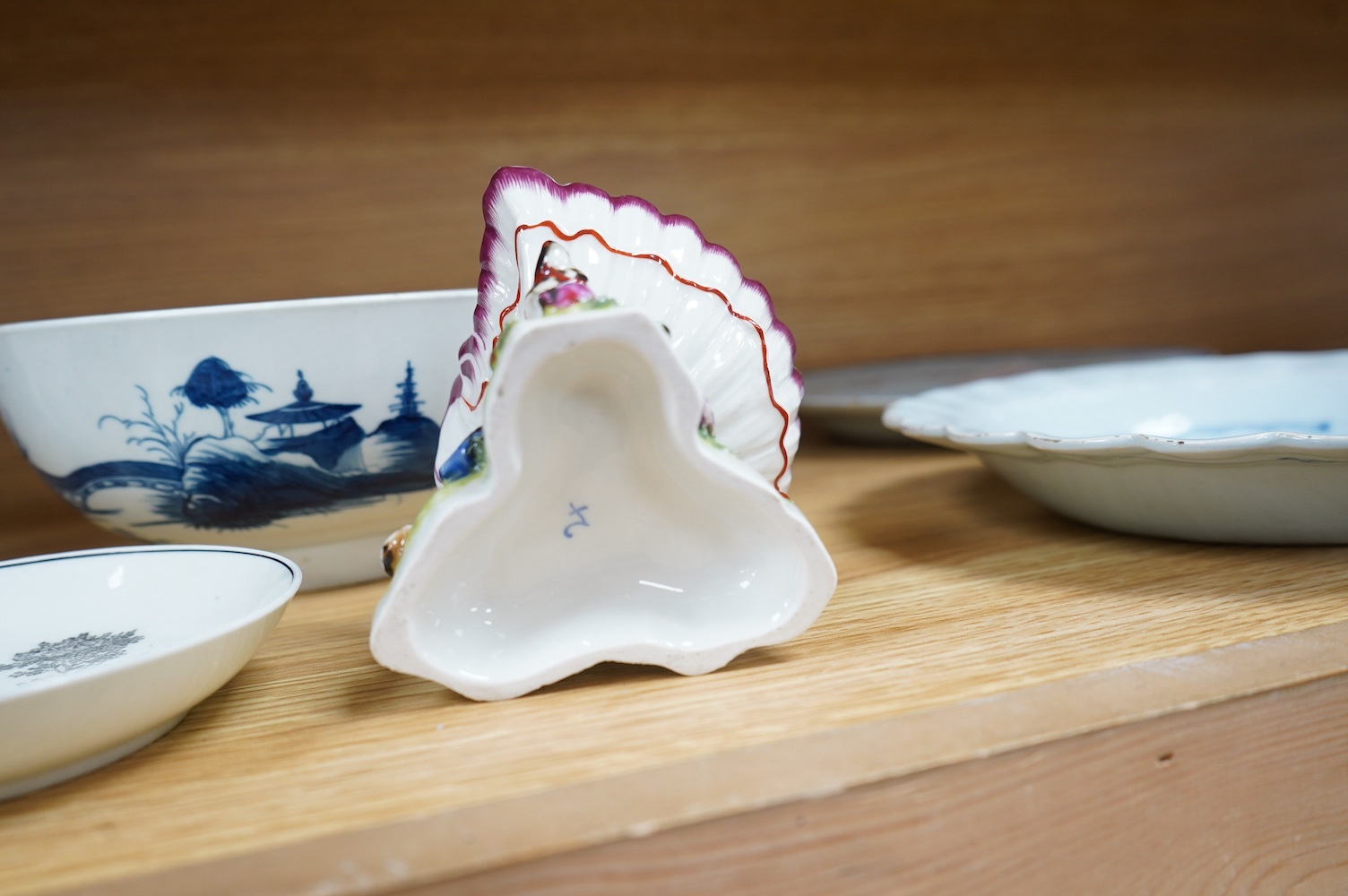 A Worcester coffee cup and saucer, Milkmaid pattern by Hancock, a pair of English porcelain shell salts, and a Worcester blue and white bowl, 18cm (5). Condition - fair